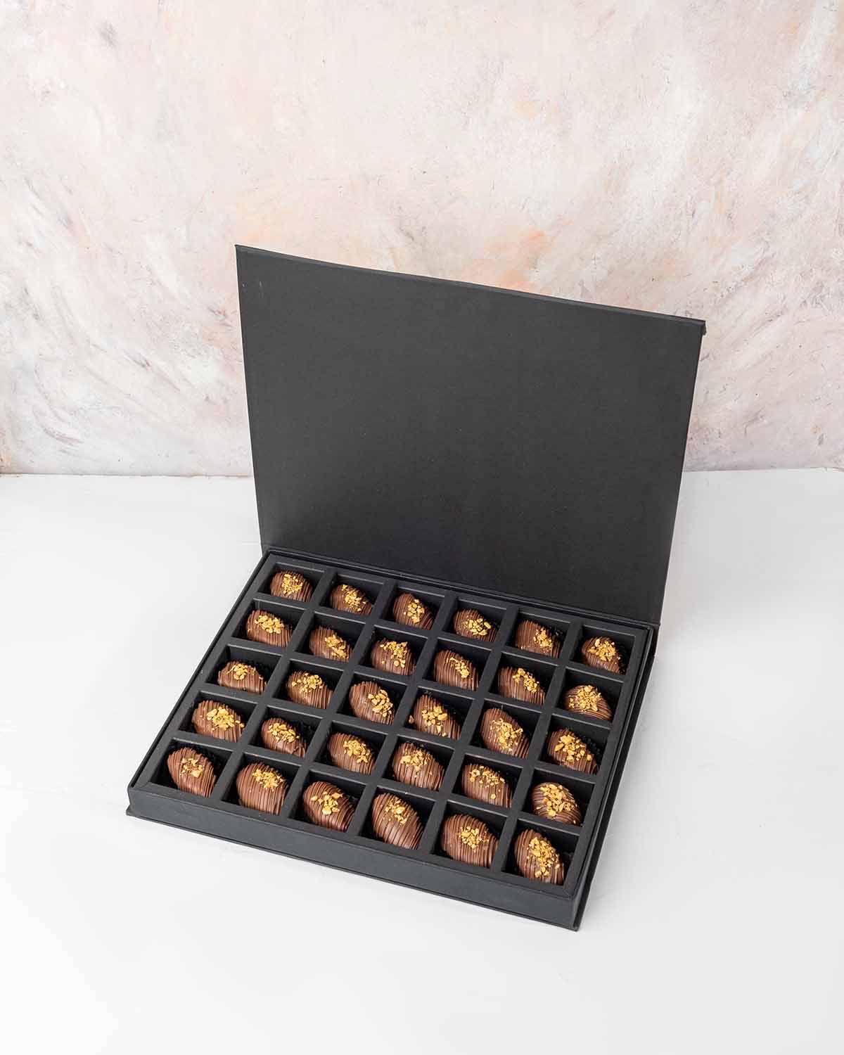30 Chocolate Covered Dates by NJDChocolate & ConfectioneryYour Gift Contains:• 30 x Belgian Milk Chocolate covered Premium Majdoul dates • Box Size: 31x26x3.5cmHandling and Storage • Keep away from direct heat and sunlight• Best stored between 12-18 °C• S